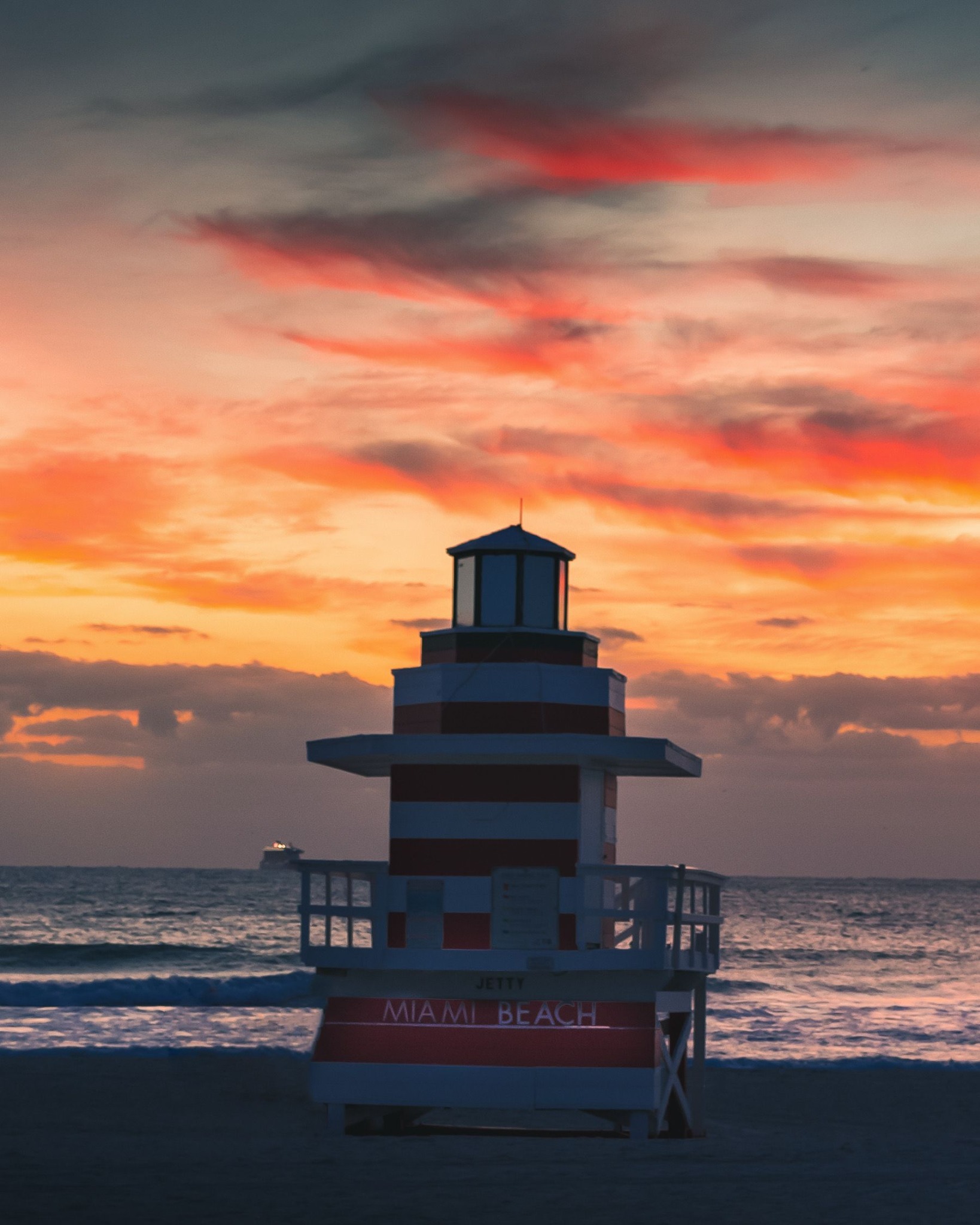 Miami Beach lifeguard tower silhouetted against a vivid sunset